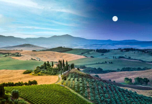 Scenic Tuscany landscape with rolling hills and valleys in beautiful moonlight at dawn, Val d'Orcia, Italy.