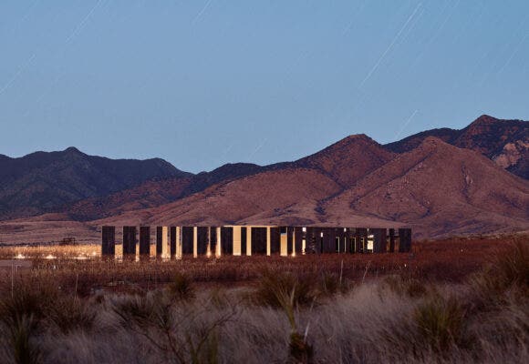 Los Milics Vineyard tasting room buiding in middle of desert, lit up at night